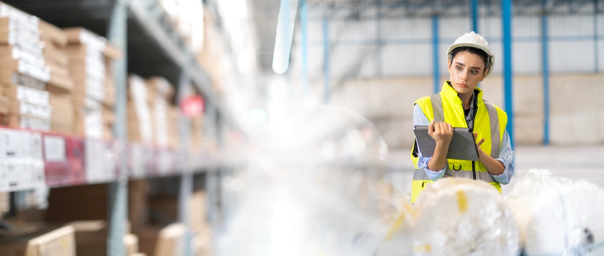 Operations team member checking a process on a tablet in a warehouse